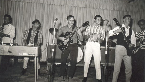 Mauroks photo, from left: Tony from Asmara on sax, Lauren 'Larry' Keiser going wild on the keyboards, Daniel Pomerleou on guitar, unknown playing the tambourine, Howard 'Butch' Salada playing the left-handed Gibson SG guitar, and Al Trautman is playing bass in the striped shirt on the far right.